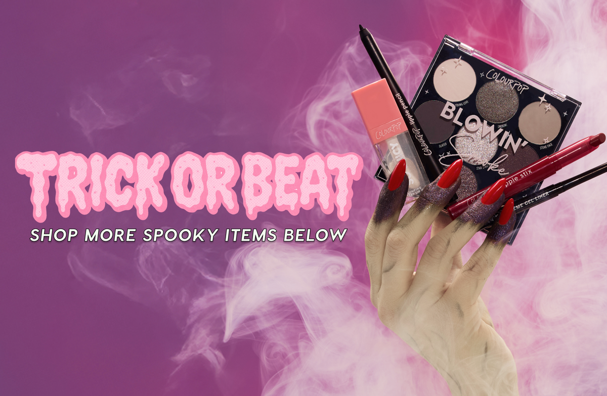 Glamorous spooky hand with long red nails holds Colourpop eyeshadow palette, lip products, and eyeliner against pink smoky background with “Trick or Beat” Halloween promo text, advertising Colourpop makeup for a Halloween look in the US.
