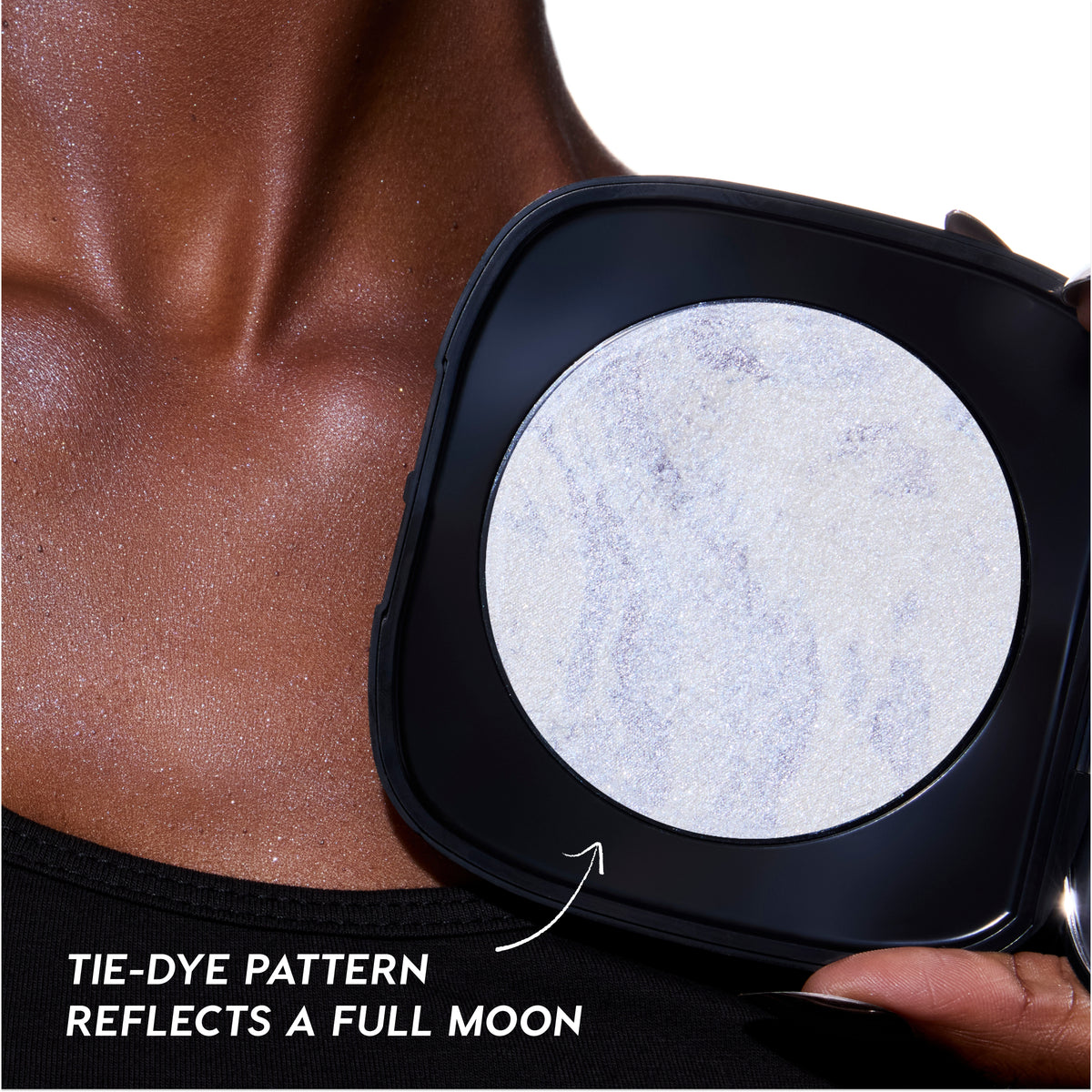 Change Me mega highlighter compact in a black square case with a marbled, full-moon-inspired pan held against a shimmering deep skin tone neck, showcasing the intense Twilight glow payoff and tie-dye pattern finish.
