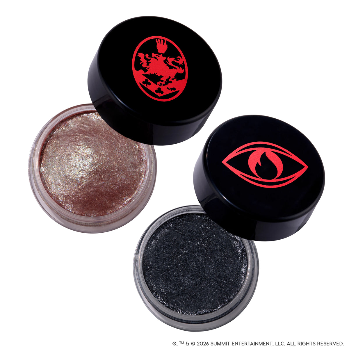 Coven Clash Jelly Much Duo Twilight makeup set showing two open gel eyeshadows, one shimmery rose gold and one sparkly charcoal black, in clear pots with black lids featuring bold red Twilight-inspired crest and eye symbols on a white background.