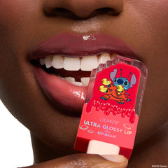ColourPop Ultra Glossy Lip Experiment 626 tube pressed to glossy mauve lips, displaying a red popsicle-shaped container with Disney Lilo & Stitch graphic; high-shine finish and smooth texture emphasize the lip gloss’s color payoff.
