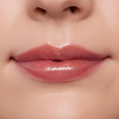 Lips wearing ColourPop Ultra Glossy Lip in Flynn Rider, showing a high-shine sheer rosy nude finish on a close-up model mouth, smooth even coverage and wet-look gloss under studio lighting for a plump, hydrated look.