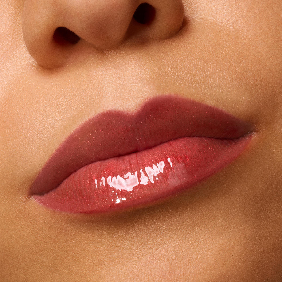 Glossed lips wearing ColourPop Ultra Glossy Lip in Runs with Vampires, a deep rosy-red tint, reflecting a glassy shine; macro close-up highlights the smooth, hydrated finish against natural skin.
