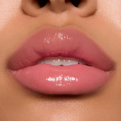 Glossy pink lips wearing ColourPop Ultra Glossy Lip in Super Sweet, showcasing a sheer warm pink tint with a glassy, high-shine finish in a studio close-up, highlighting smooth, hydrated texture and precise application.
