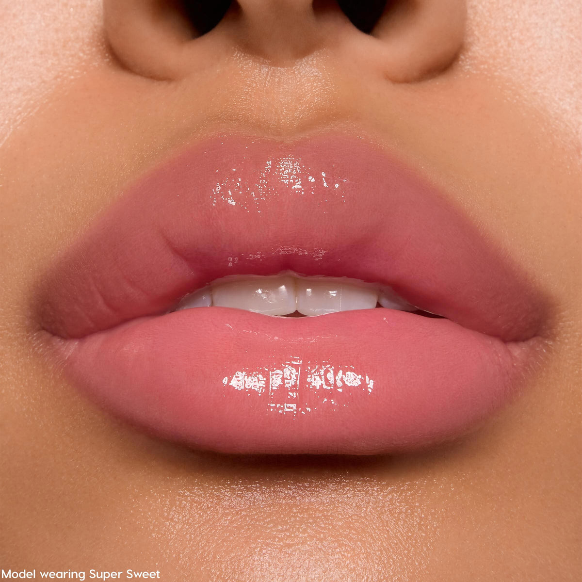Soft pink lips wearing Keepin’ It Sweet Ultra Glossy Lip, a ColourPop Ultra Glossy Lip, reflecting a glassy high-shine finish in a tight studio close-up that showcases smooth, hydrated texture and a sheer rosy tint.