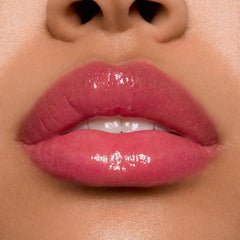 Glossy lips wearing ColourPop Ultra Glossy Lip in Surfer Vibes, delivering a sheer rosy pink tint with a high-shine, glassy finish in a tight studio close-up that highlights even coverage and reflective shine.