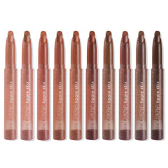 ColourPop Lippie Stix line up showing In the Nude collection - ten twist-up lipsticks in clear tubes, ranging from peach and pinky beige to warm caramel and deep brown - standing upright on a white background.