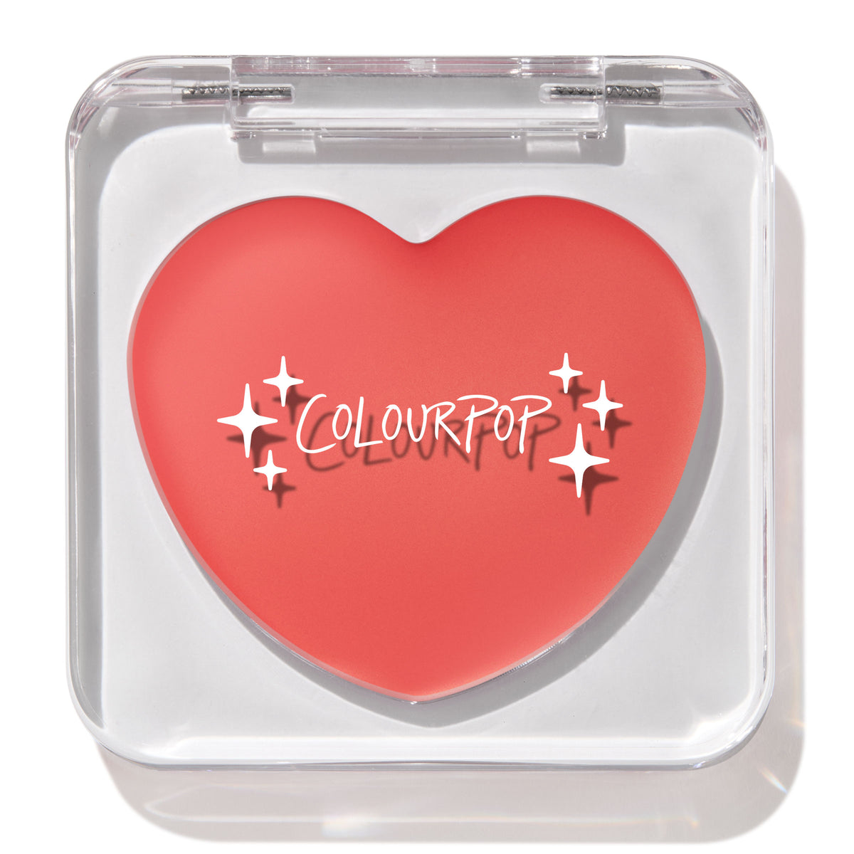 Heart-shaped Baby Bunny ColourPop Lip and Cheek Balm shown closed in a clear square compact, coral-pink tint with white sparkle graphics and ColourPop logo, displayed under studio light on a white background.