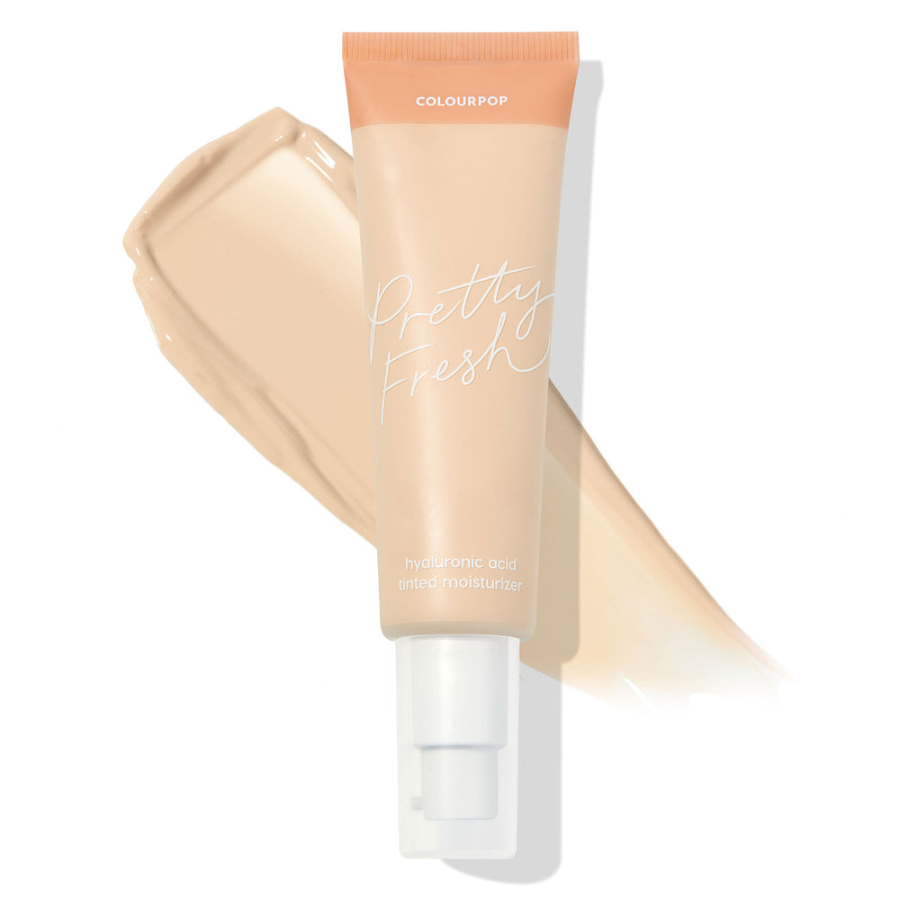 ColourPop Pretty Fresh Tinted Moisturizer tube in Fair 1 N stands with a white pump and peach cap over a creamy beige swatch, showcasing the neutral fair shade and hyaluronic acid formula for light, dewy coverage.