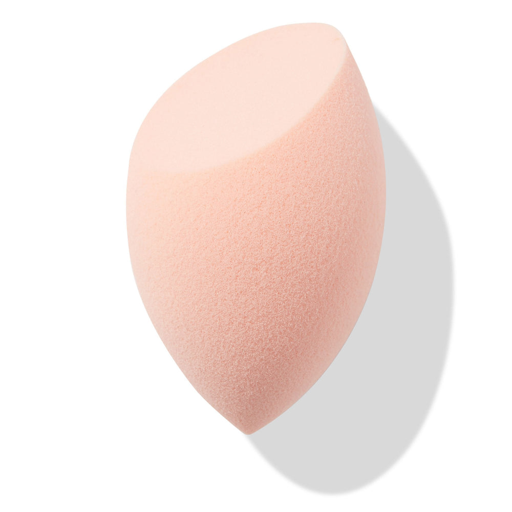 Peach teardrop Blending Sponge with a flat slanted edge resting at an angle, showing fine foam texture for seamless foundation and concealer blending, isolated on white with soft shadow; a must-have in ColourPop Makeup Tools & Accessories.