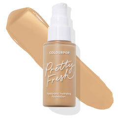 ColourPop Hyaluronic Hydrating Foundation, Pretty Fresh Medium 110 W, stands with a white pump as its warm beige shade is swatched in a thick streak behind the frosted bottle on a white background.