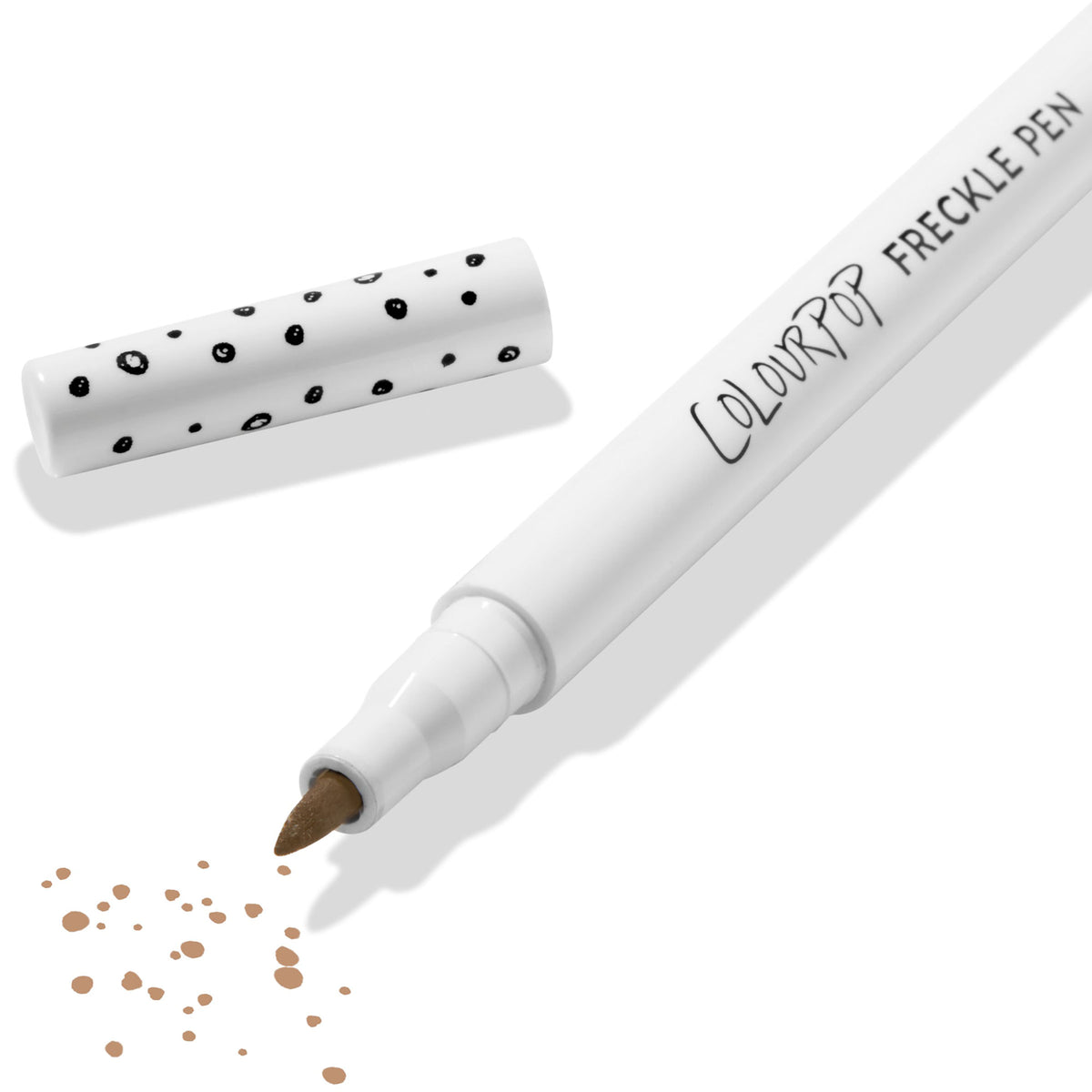 ColourPop Freckle Pen in Soft Brown uncapped, felt-tip applying scattered soft brown freckle dots, with polka-dot white cap beside it on a clean white background; long-wearing, buildable faux freckles makeup.