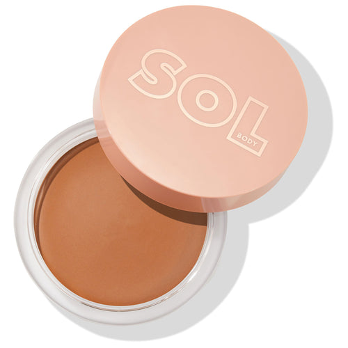 Medium Dark bronzing balm displaying a smooth, creamy tan surface in a clear round jar, the peach SOL Body lid set askew, studio-lit on white; ColourPop SOL Face & Body Bronzing Balm for face and body, buildable sun-kissed warmth.