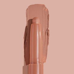 ColourPop Shadow Stix in Bare With Me smoothly swiped into a thick matte peachy-nude swatch, the crayon tip centered in close-up on a matching nude background, highlighting the creamy, long-wear eyeshadow stick.