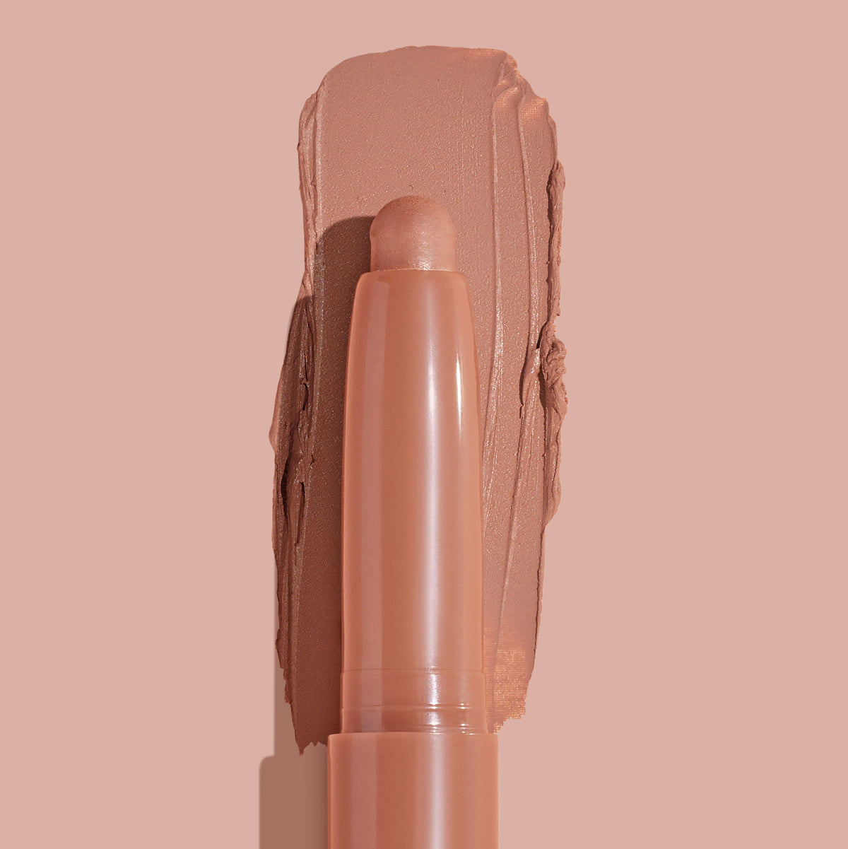 ColourPop Shadow Stix in Bare With Me smoothly swiped into a thick matte peachy-nude swatch, the crayon tip centered in close-up on a matching nude background, highlighting the creamy, long-wear eyeshadow stick.